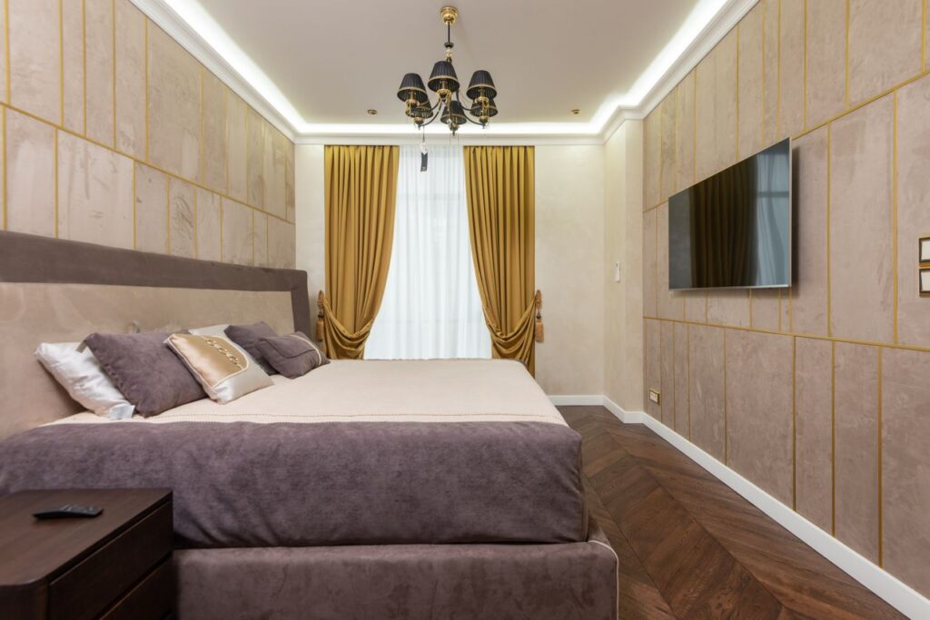 Luxury bedroom interior design with gold accents and TV wall
