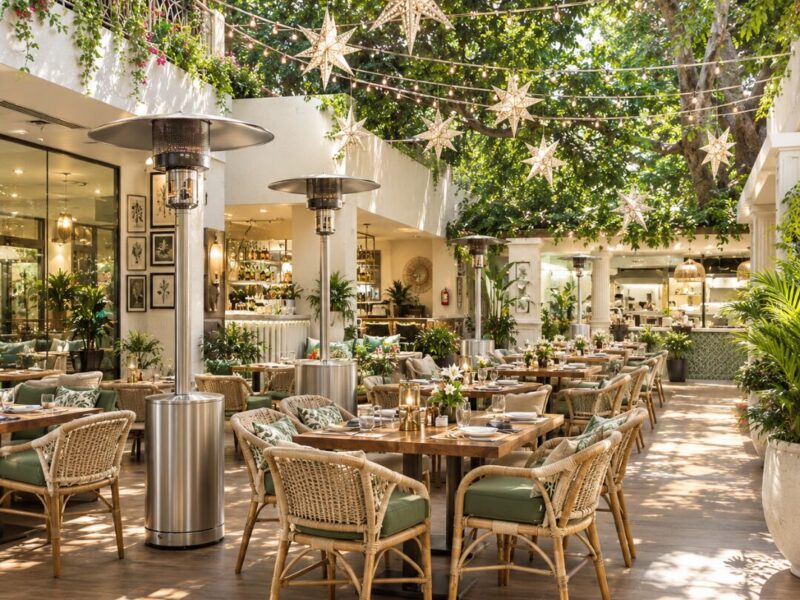Open courtyard restaurant terrace with cane chairs, string lights and star lanterns by Elegant Decors