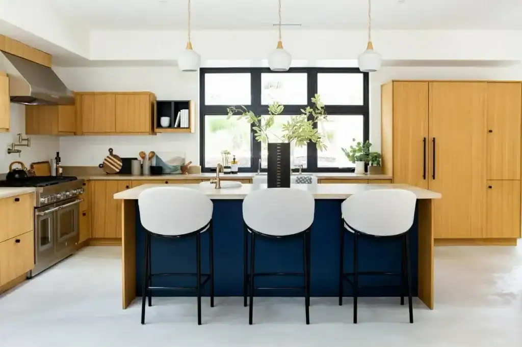 Modern kitchen with wooden cabinets, blue island, and white countertops.