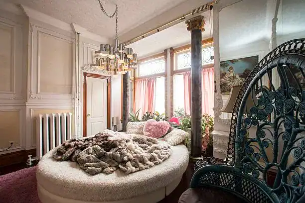 Luxurious vintage bedroom with ornate iron bed and plush faux fur throw.
